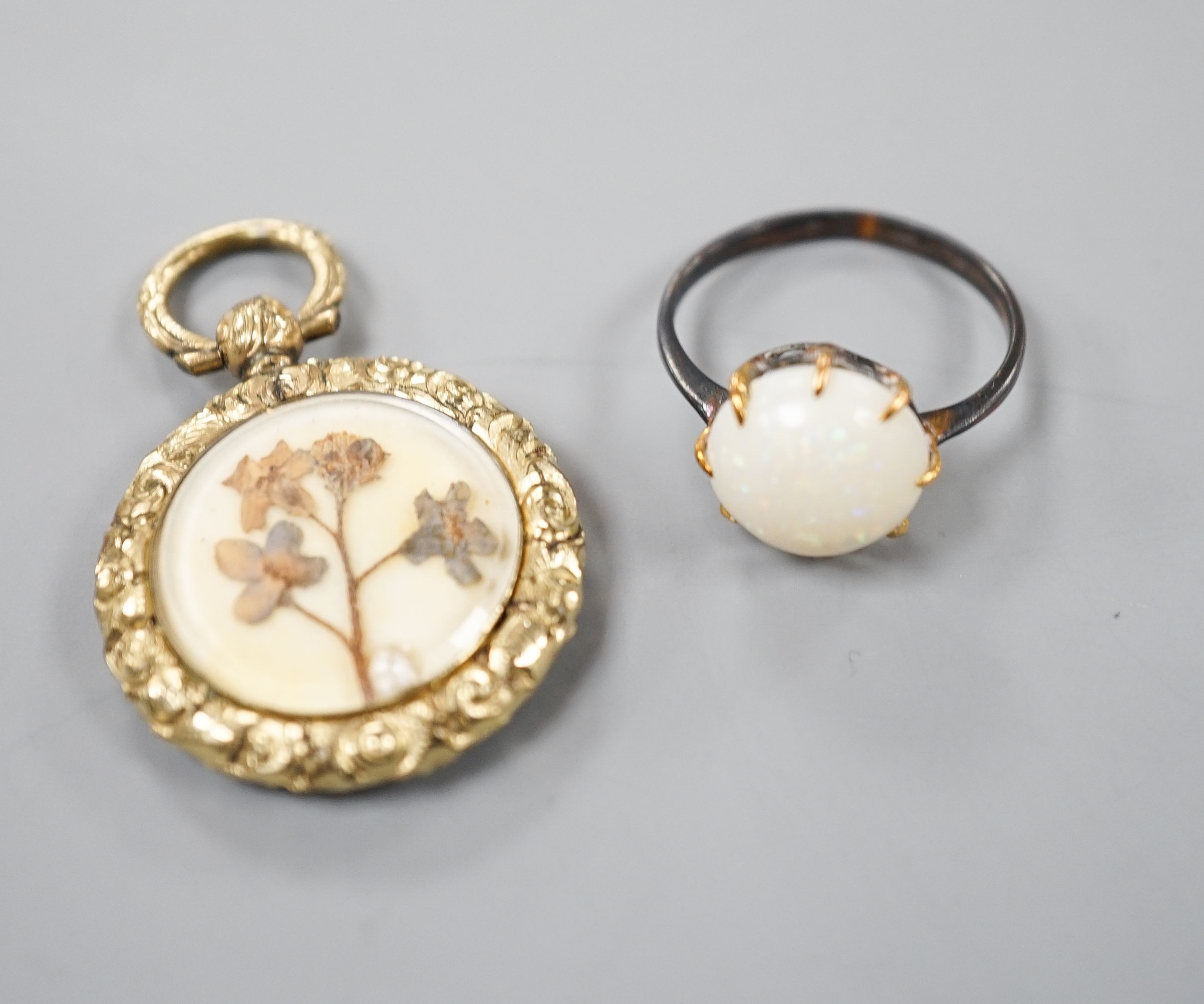 A yellow metal and white opal ring, size K/L and a late Victorian engraved yellow metal pendant, 25mm.